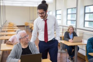 Formador impartiendo un curso de informática a personas adultas
