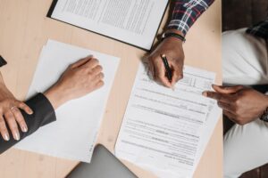 Dos personas revisando documentos y certificados en una mesa de oficina